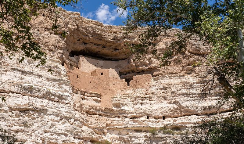 Montezuma Castle, a five-story Sinagua cliff dwelling tucked into an alcove of a pale limestone cliff.